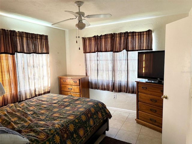 bedroom featuring multiple windows, light tile patterned flooring, and ceiling fan