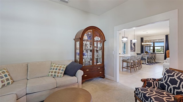 carpeted living room featuring a notable chandelier