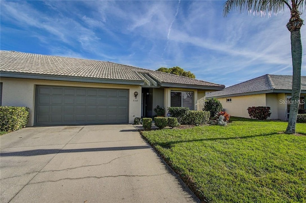 single story home with a garage and a front lawn