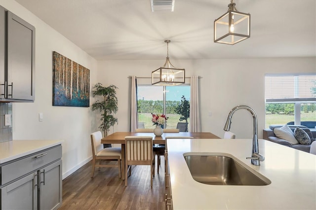 kitchen featuring gray cabinets, a wealth of natural light, sink, and pendant lighting