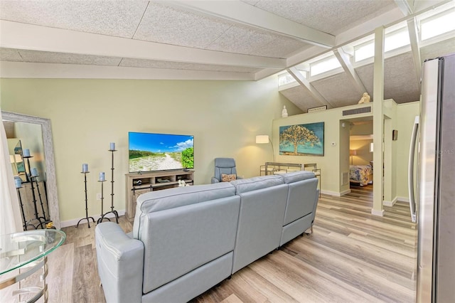 living room featuring lofted ceiling with beams and light hardwood / wood-style floors