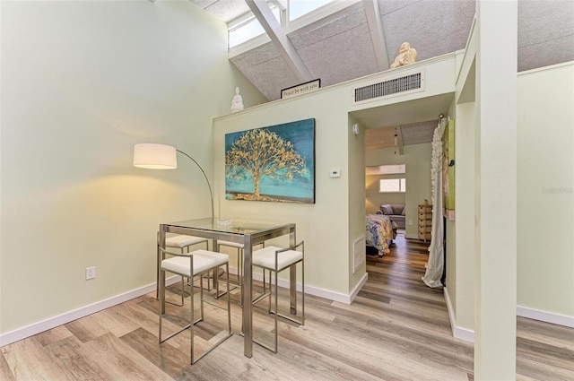 dining space with hardwood / wood-style flooring and a towering ceiling