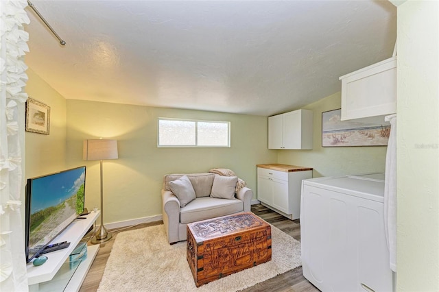 washroom with cabinets, washer / dryer, and light hardwood / wood-style floors