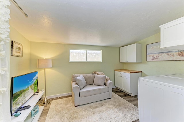 interior space with cabinets, washer / dryer, and light hardwood / wood-style floors