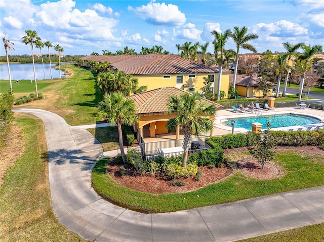 exterior space featuring a patio area, a lawn, and a water view