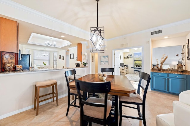 dining area featuring an inviting chandelier, crown molding, and a raised ceiling