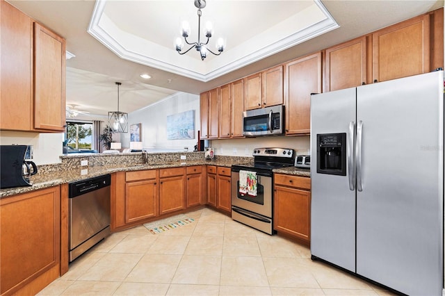 kitchen featuring sink, a chandelier, hanging light fixtures, a tray ceiling, and stainless steel appliances