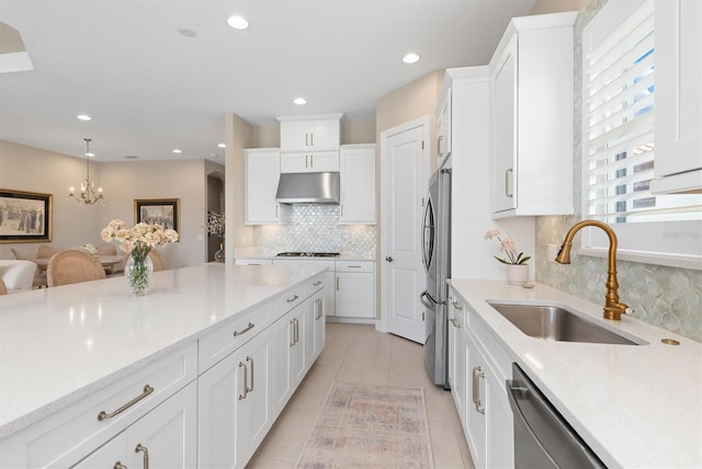 kitchen with white cabinetry, stainless steel appliances, sink, and hanging light fixtures