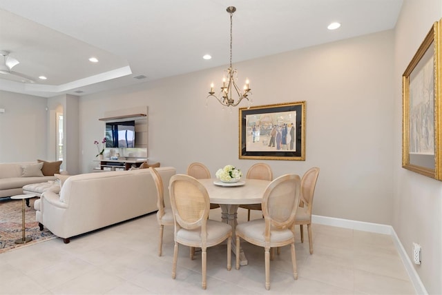 dining space with a notable chandelier and a tray ceiling