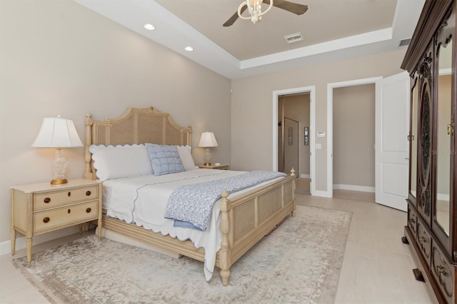 bedroom featuring a raised ceiling and ceiling fan