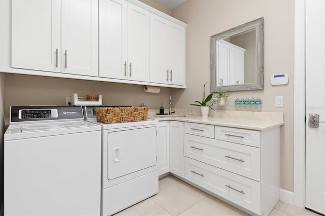 washroom with cabinets, sink, light tile patterned floors, and independent washer and dryer