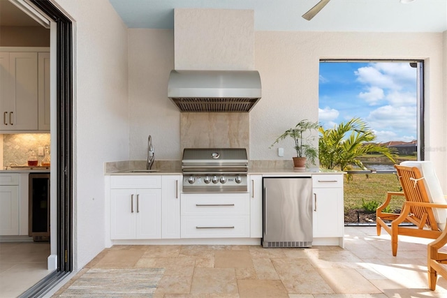 kitchen featuring sink, backsplash, fridge, white cabinets, and beverage cooler