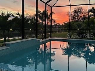 pool at dusk with a lanai