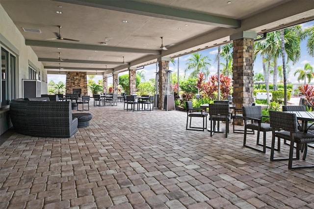 view of patio with ceiling fan and an outdoor stone fireplace