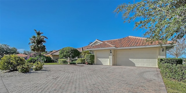 view of front of property with an attached garage, stucco siding, decorative driveway, and a tiled roof