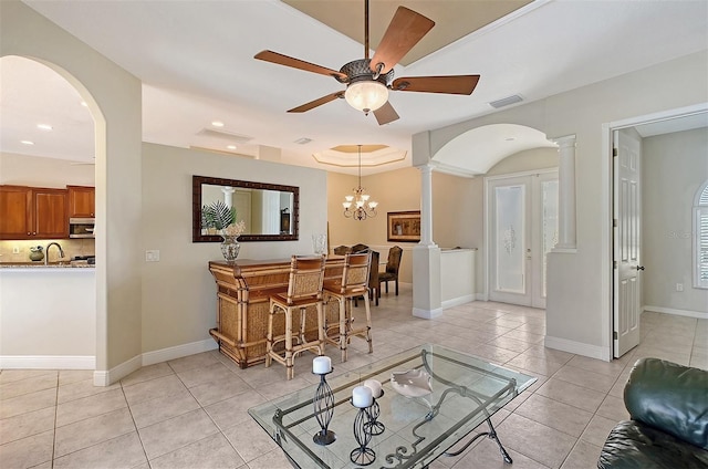 tiled living room featuring decorative columns and ceiling fan