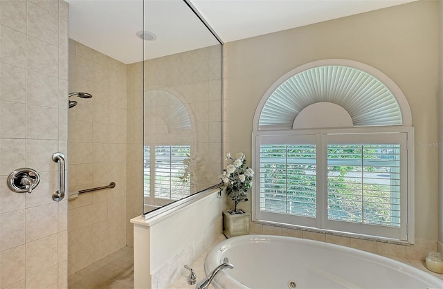 bathroom featuring a tub with jets and walk in shower