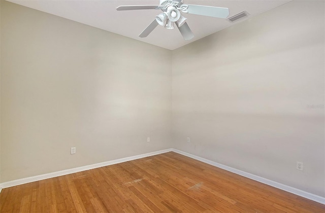 empty room featuring light wood-style floors, visible vents, baseboards, and a ceiling fan