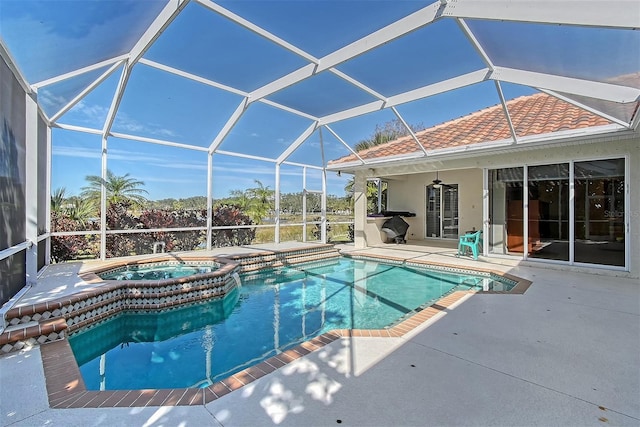 view of swimming pool featuring glass enclosure, a pool with connected hot tub, and a patio