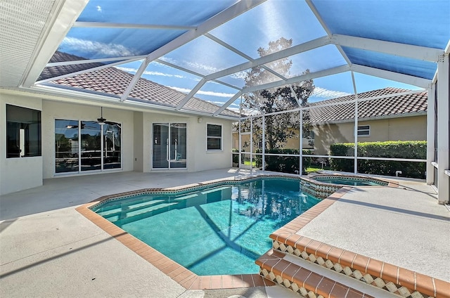 view of pool featuring ceiling fan, a patio, glass enclosure, and an in ground hot tub