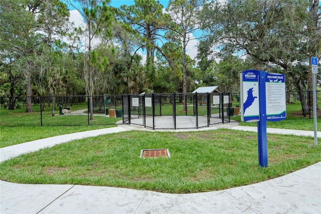 view of community featuring a gate, a yard, and fence