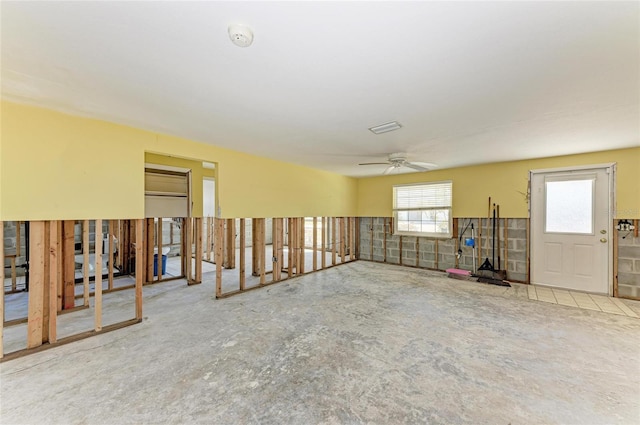 empty room with ceiling fan and concrete floors