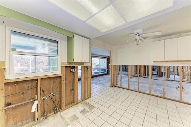 kitchen with light tile patterned flooring, white cabinetry, and ceiling fan