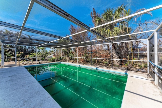 view of pool featuring glass enclosure