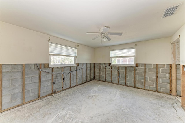 spare room with ceiling fan and concrete floors