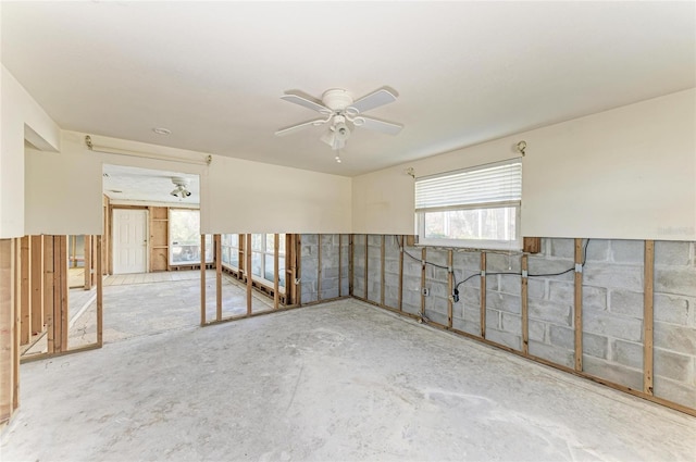 unfurnished room featuring ceiling fan and concrete floors