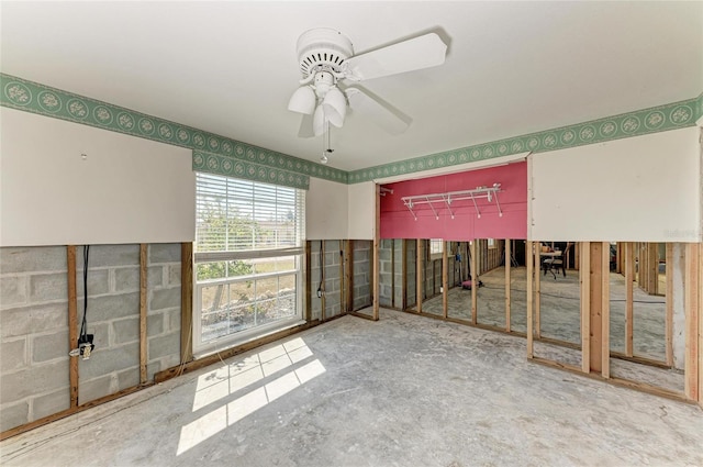 unfurnished room featuring ceiling fan and concrete floors