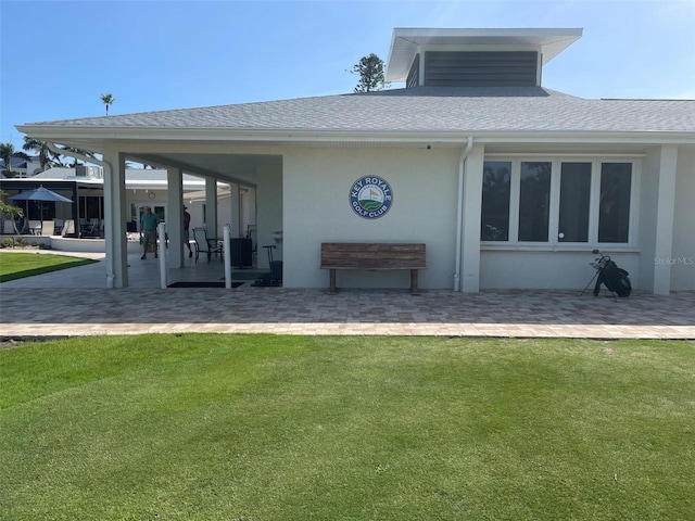 rear view of house with a patio and a lawn