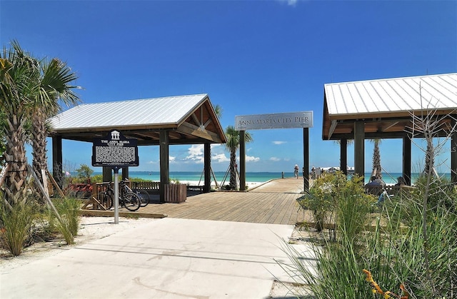 dock area with a water view, a gazebo, and a beach view