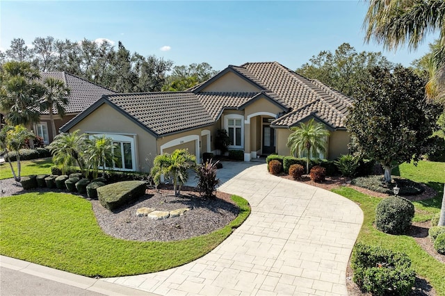 mediterranean / spanish-style home with a front lawn and a garage