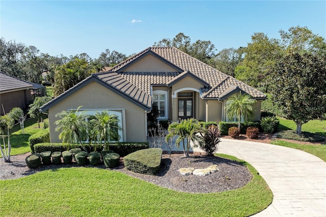 mediterranean / spanish home with french doors and a front lawn