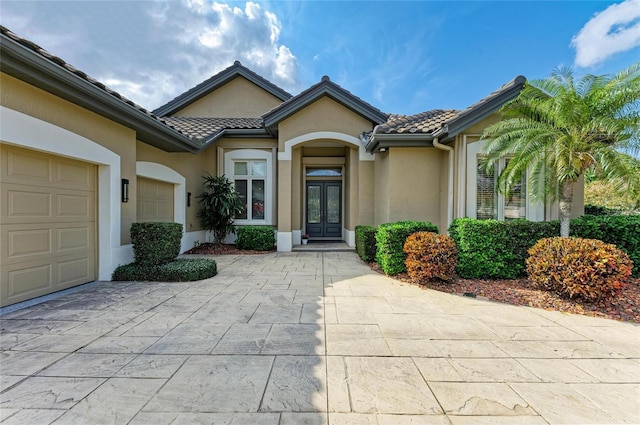 view of exterior entry with french doors and a garage