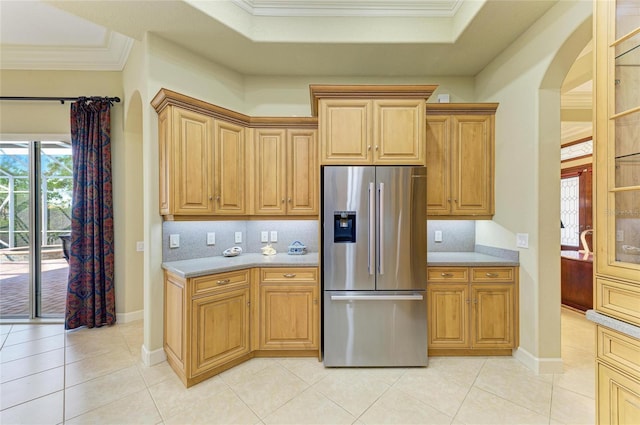 kitchen with stainless steel refrigerator with ice dispenser, crown molding, tasteful backsplash, and light tile patterned floors