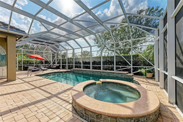 view of pool with a patio, glass enclosure, and an in ground hot tub