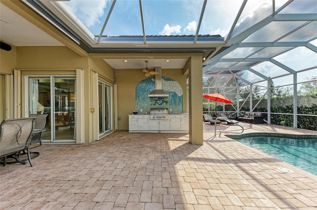 view of swimming pool with an outdoor kitchen, grilling area, glass enclosure, and a patio area