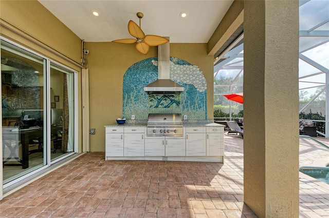 view of patio / terrace featuring ceiling fan, an outdoor kitchen, area for grilling, and glass enclosure