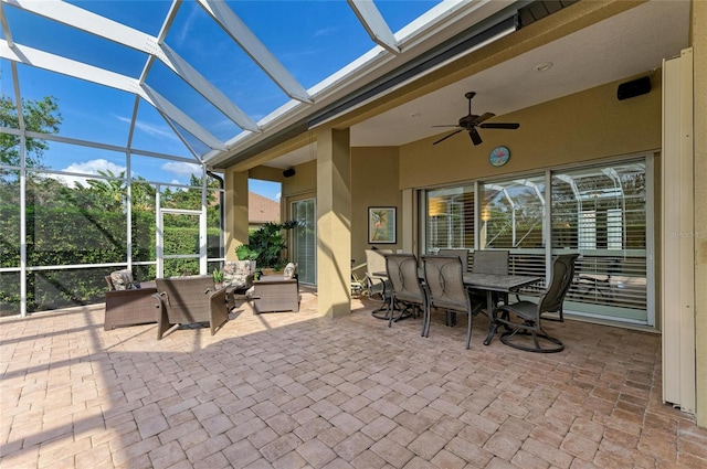 view of patio featuring ceiling fan and glass enclosure