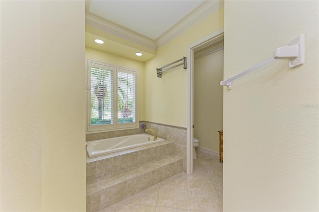 bathroom with tile patterned floors, ornamental molding, toilet, and tiled bath