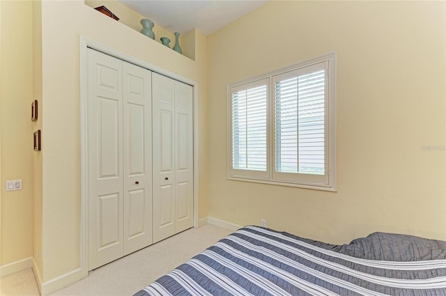 bedroom with light colored carpet and a closet