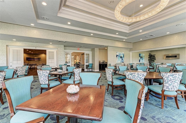 dining room featuring crown molding and a raised ceiling