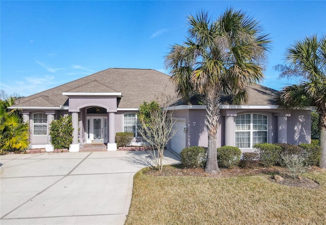 ranch-style house with a garage and a front lawn