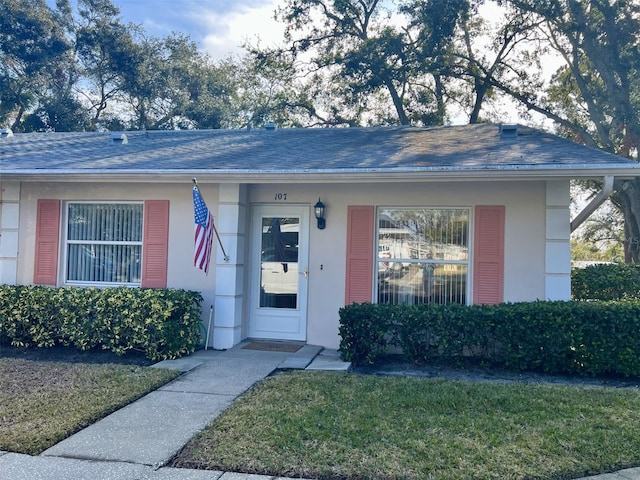 property entrance featuring a lawn