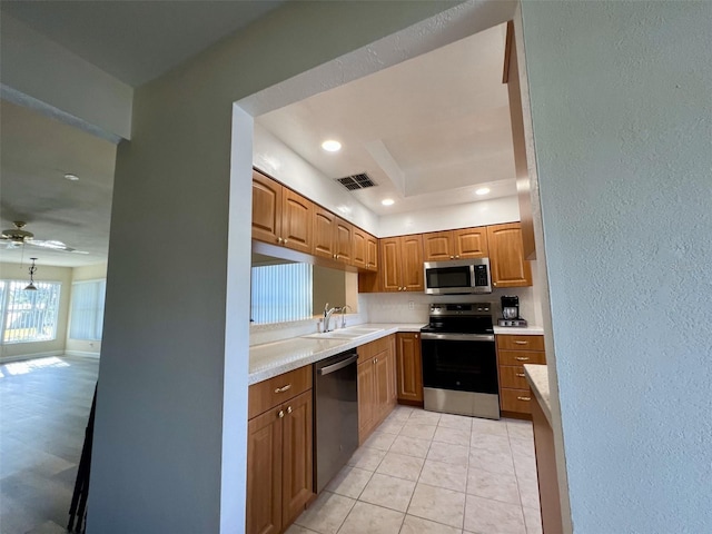 kitchen with sink, ceiling fan, appliances with stainless steel finishes, tasteful backsplash, and light tile patterned flooring