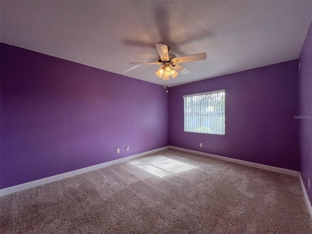 empty room featuring carpet flooring and ceiling fan