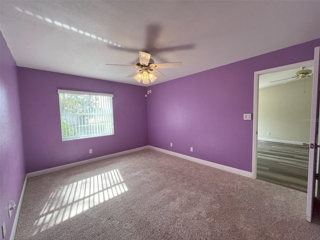 carpeted empty room featuring a textured ceiling and ceiling fan