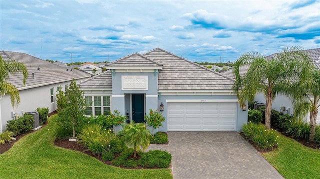 view of front of home with central AC, a garage, and a front lawn